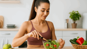 Mulher em cozinha moderna preparando salada fresca com vegetais, reforçando hábitos saudáveis.