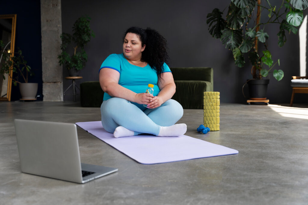 Mulher iniciando prática de exercícios em casa com apoio online, representando motivação e saúde no processo de emagrecimento.