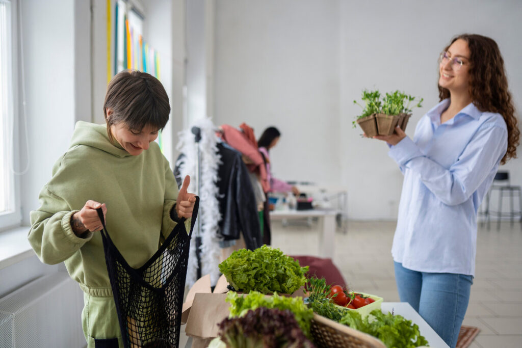 Mulheres escolhendo vegetais frescos em feira local, simbolizando hábitos saudáveis e alimentação natural para emagrecimento consciente.