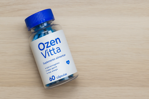 Frasco do suplemento OzenVitta sobre superfície de madeira, representando o produto utilizado no processo de emagrecimento.