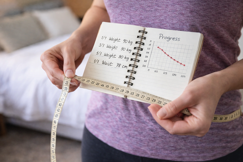Pessoa acompanhando evolução no emagrecimento com medidas e progresso