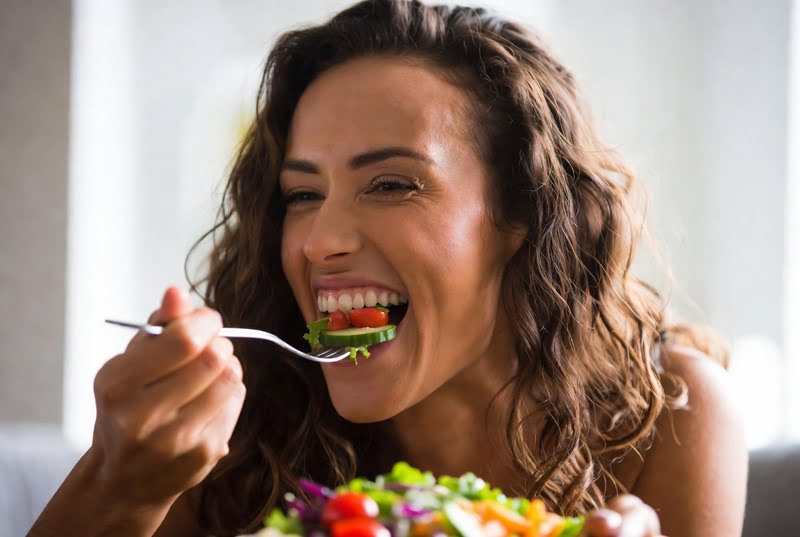 Perca Peso Rindo – Mulher rindo enquanto come salada