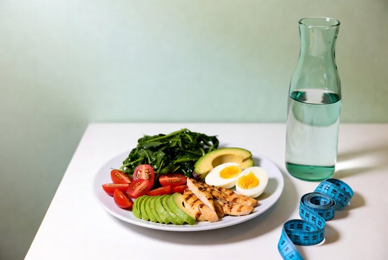 Prato com refeição equilibrada contendo salada, abacate, frango grelhado e ovos para emagrecer de forma saudável