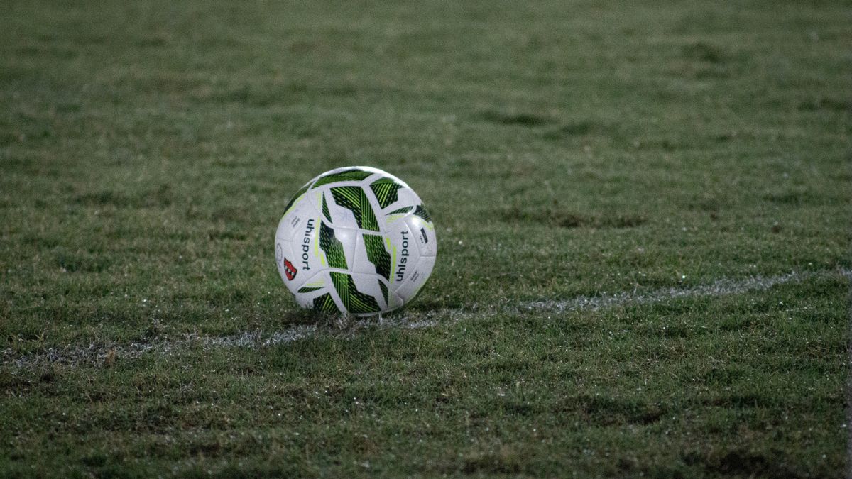 bola de futebol no campo representando emagrecer jogando bola com aquecimento