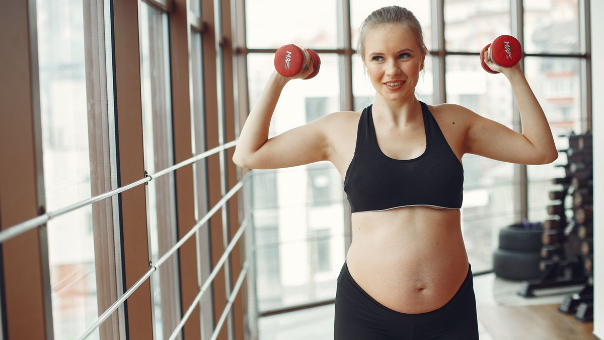 Mulher se exercitando com bebe ao lado