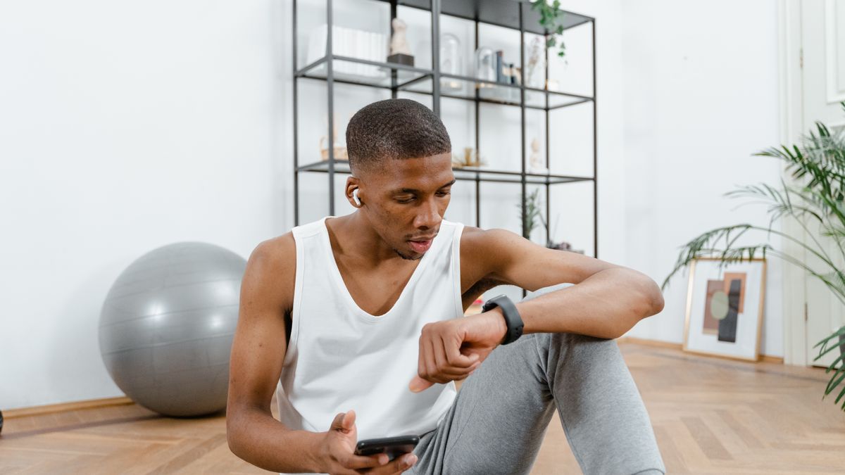 homem checando progresso de treino no smartwatch após exercício