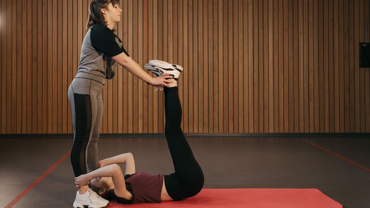 dupla fazendo alongamento no tapete para melhorar flexibilidade