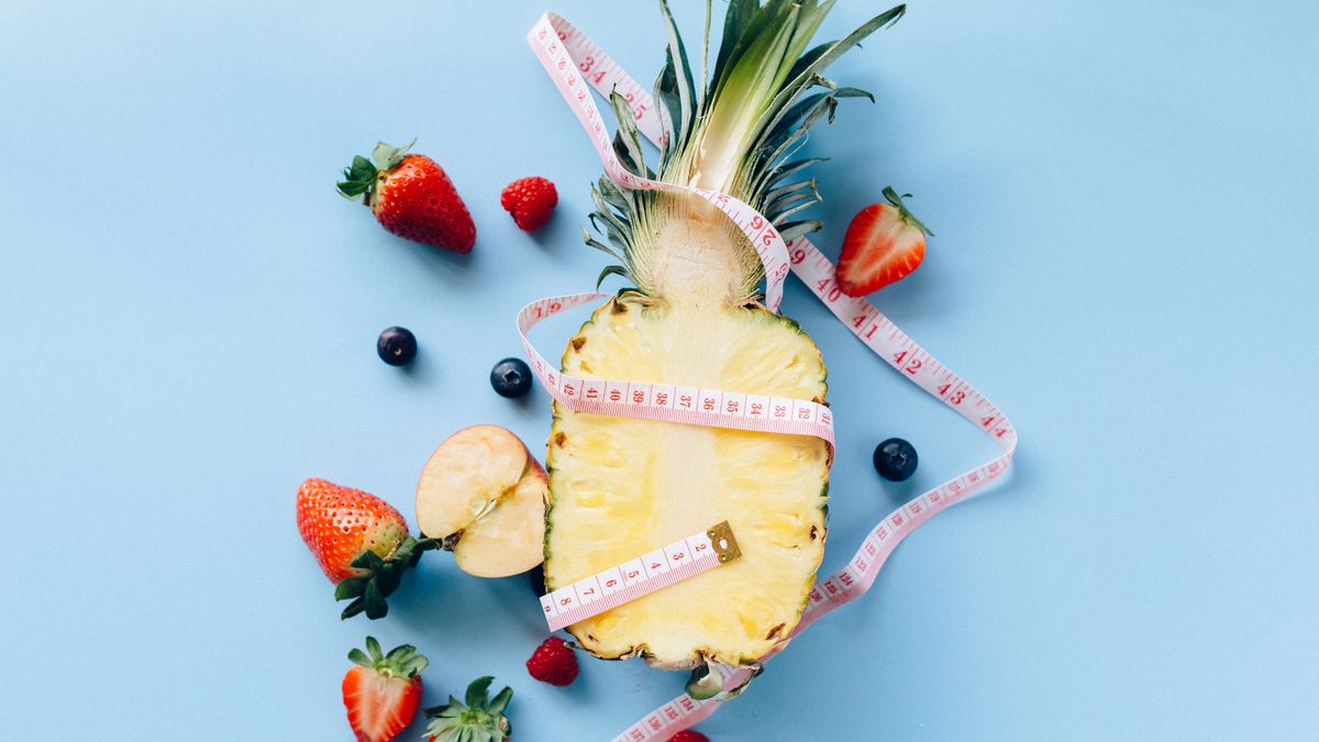 frutas frescas com fita métrica representando alimentação saudável e emagrecimento