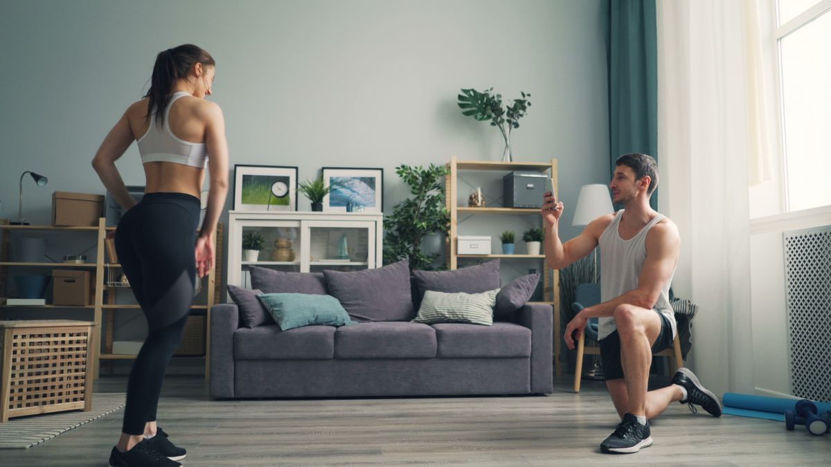 casal exercitando-se juntos na sala de casa em treino de resistência